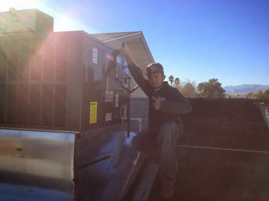 HVAC technician performing AC Tune-Up on a rooftop unit in Midlothian